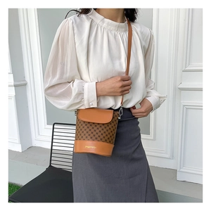 Sac seau vintage marron à imprimé porté par un mannequin en extérieur naturel