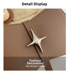 Détail du sac en cuir marron avec ornement métallique en étoile argentée et couture