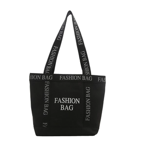 Black canvas tote bag with white FASHION BAG prints and spacious interior for daily commute