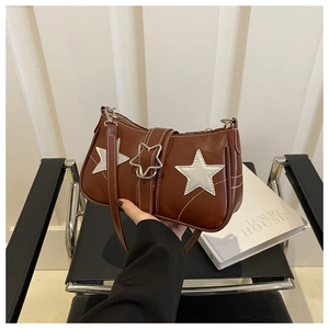 Détail d'un sac à bandoulière marron à motif d'étoile avec coutures blanches et boucle