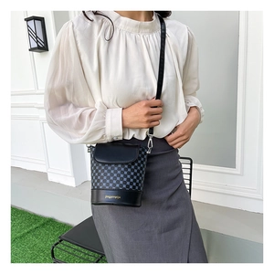 Détail du sac seau vintage à motif géométrique avec rabat en cuir et bandoulière noire