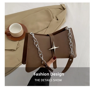 Détail du sac bandoulière en cuir marron avec fermoir étoile argenté et bandoulière chaîne