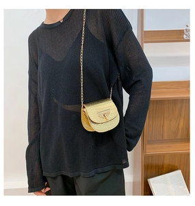 Detail of golden crocodile pattern saddle bag with elegant metal chain strap