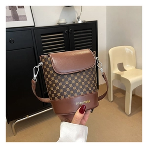 Détail du sac seau vintage avec base en cuir contrastée et lettrage de la marque