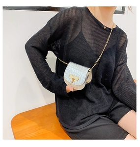 Silver crocodile texture mini saddle bag with gold chain strap shown on model outfit