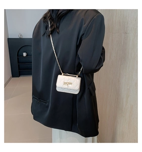 Back view of model wearing a white quilted mini chain bag with gold hardware and turn-lock