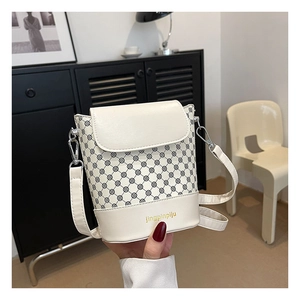 Détail du sac seau blanc avec motif à pois et logo sur la partie en cuir synthétique