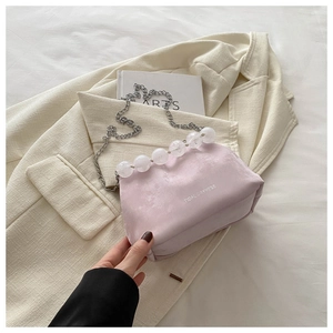 Detailed macro of pink velvet bucket bag with silver chain and clear crystal bead handle