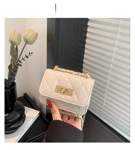 Detail of creamy white quilted mini bag with gold twist lock and chain strap