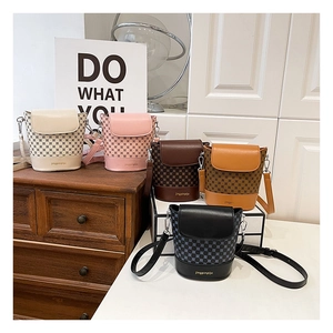 Détail de cinq sacs seaux vintage avec imprimé logo en blanc, rose, marron, jaune et noir