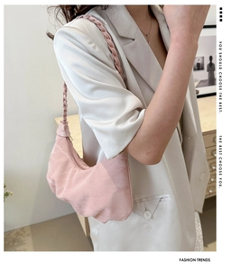 Détail du sac croissant plissé rose avec tissu texturé et poignée tressée
