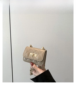 Close-up of mini quilted shoulder bag in khaki with gold chain and twist lock