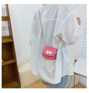 Pink mini saddle bag with crocodile texture and gold chain strap shown on a model