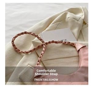 Macro shot of the soft pink woven shoulder strap detail on a pleated hobo bag