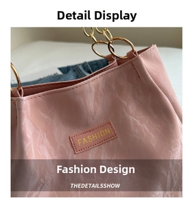 Dettaglio della borsa tote rosa in pelle stropicciata con manico ad anello dorato