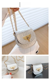 Detailed views of a silver crocodile-embossed saddle bag with a gold chain strap and ring lock
