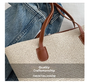 Close-up of beige woven tote bag featuring brown leather handles with contrast stitching