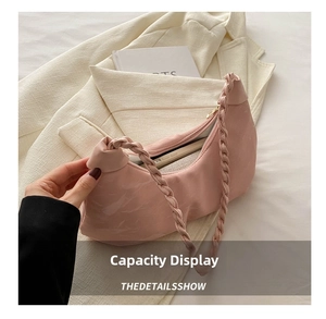 Pink crescent shoulder bag showing internal capacity for smartphone on ivory blazer