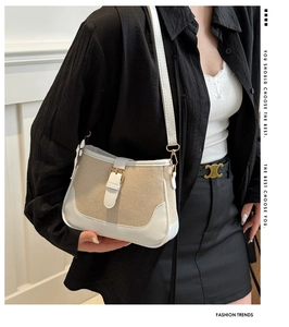Detail shot of vintage beige canvas crossbody bag with white leather trim and buckle