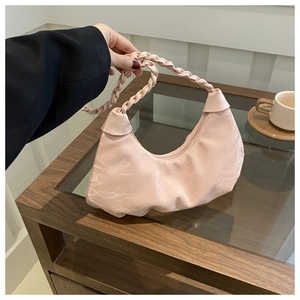 Détail du sac demi-lune plissé rose avec bandoulière tressée et fini brillant
