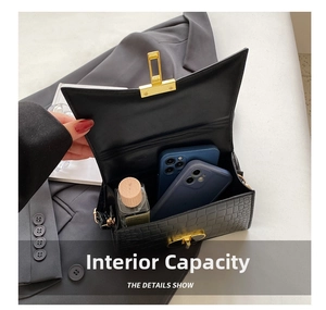 Detail view of the spacious interior of the black croc-embossed bag with golden hardware