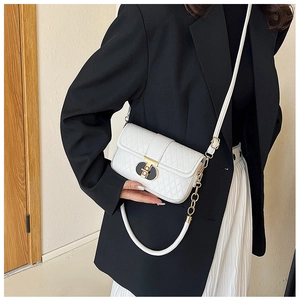Detailansicht der weißen Stepptasche mit goldfarbenen Elementen am Modestil