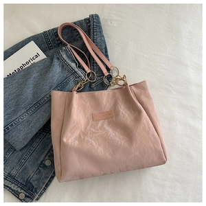 Dettaglio della borsa tote rosa lucida con etichetta Fashion e anelli in metallo dorato