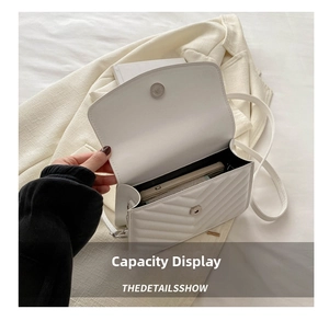 Internal view of white quilted crossbody bag showing storage capacity for mobile phones