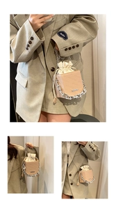 Detailed view of cream bucket bag with embossed texture and elegant silver chain strap