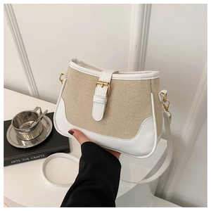 Detail of a vintage woven crossbody bag with white leather trim and golden buckle detail