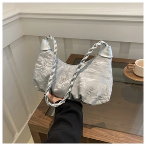 Détail du sac nuage plissé argenté avec une poignée tressée au fini métallique