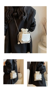 Detail of white box crossbody bag with rich rabbit embossed pattern and chunky silver chain