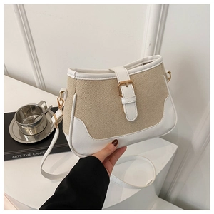 Detailed close-up of a stylish canvas and leather crossbody bag with golden metal buckle