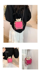 Detail of rose pink mini bucket bag with silver chain and white drawstring pouch