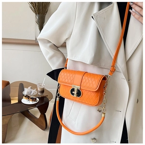 Modische orangefarbene Stepptasche mit T-Verschluss, getragen von einem Model an der Schulter