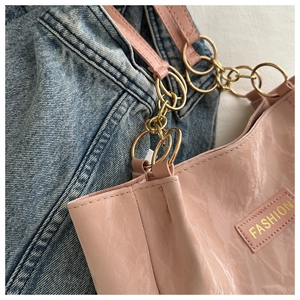 Dettaglio borsa tote rosa in vernice stropicciata con catena oro e logo Fashion