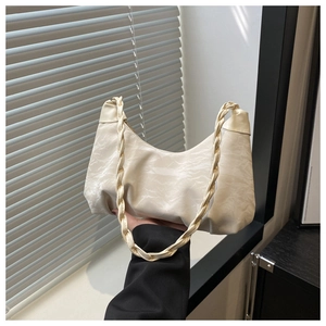 Détail de la poignée tressée et de la texture marbrée du sac croissant crème