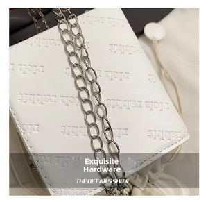 Close-up of elegant silver chain strap and rich rabbit embossed texture on white bag