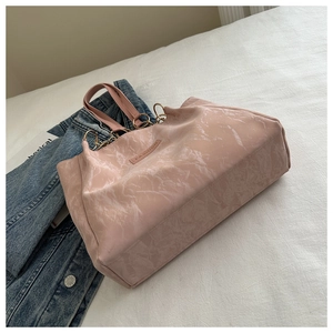 Dettaglio della borsa tote in marmo rosa con manici in pelle e anelli in metallo oro