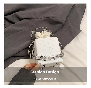 Detail shot of white square bag featuring rich rabbit embossed pattern and chain strap