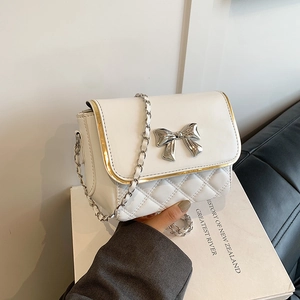 Quilted white crossbody bag with silver bow buckle and elegant gold-trimmed edge detail