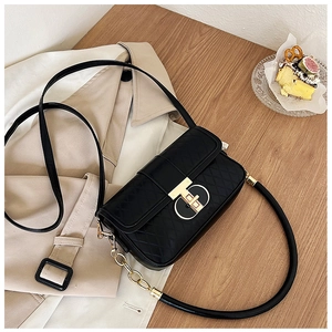 Details einer schwarzen Stepptasche mit goldenem Pyramidenverschluss und Kettenriemen