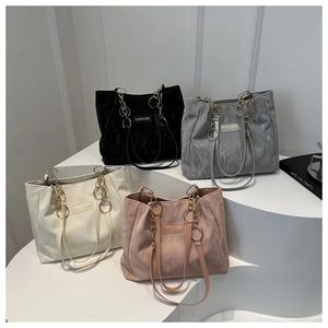Dettaglio di borse tote minimaliste in quattro colori con tracolla a catena e texture
