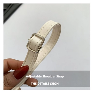 Close-up of beige leather adjustable shoulder strap with silver buckle and fine stitching