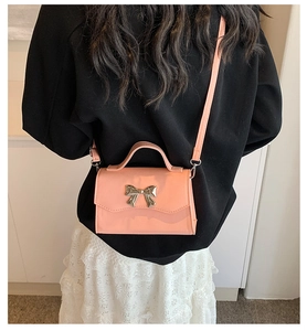 Pink shoulder bag with silver metal bow detail and adjustable crossbody strap