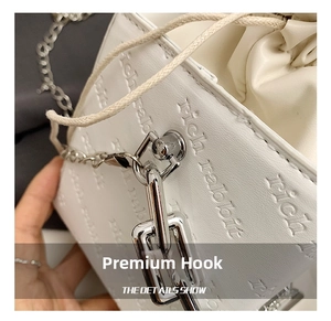 Detailed close-up of white leather drawstring bag with rich rabbit logo and silver hook