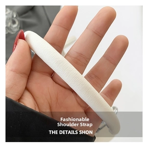 Dettaglio della tracolla in pelle bianca con trama litchi e fibbie in metallo argento
