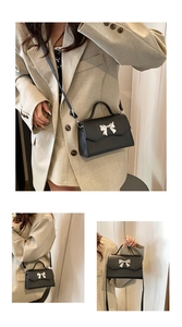 Detail of black crossbody bag with silver bow accent and pebbled leather texture
