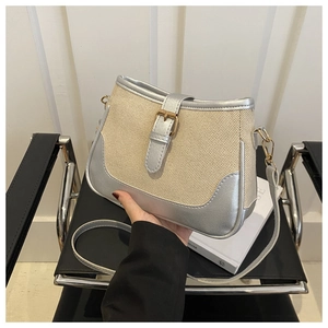 Close-up of beige woven texture and silver synthetic leather stitching on the handbag