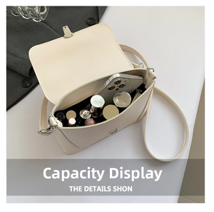Interior view of off-white shoulder bag showing capacity for phone and cosmetics